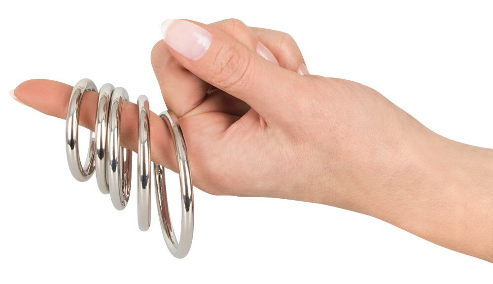 Hand hält fünf silberne Carbonstahlringe, fünfteiliger Ringsatz
