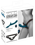 Verpacktes Strap-on-Set: Vibrationsdildo in teal mit schwarzbraunem Harness