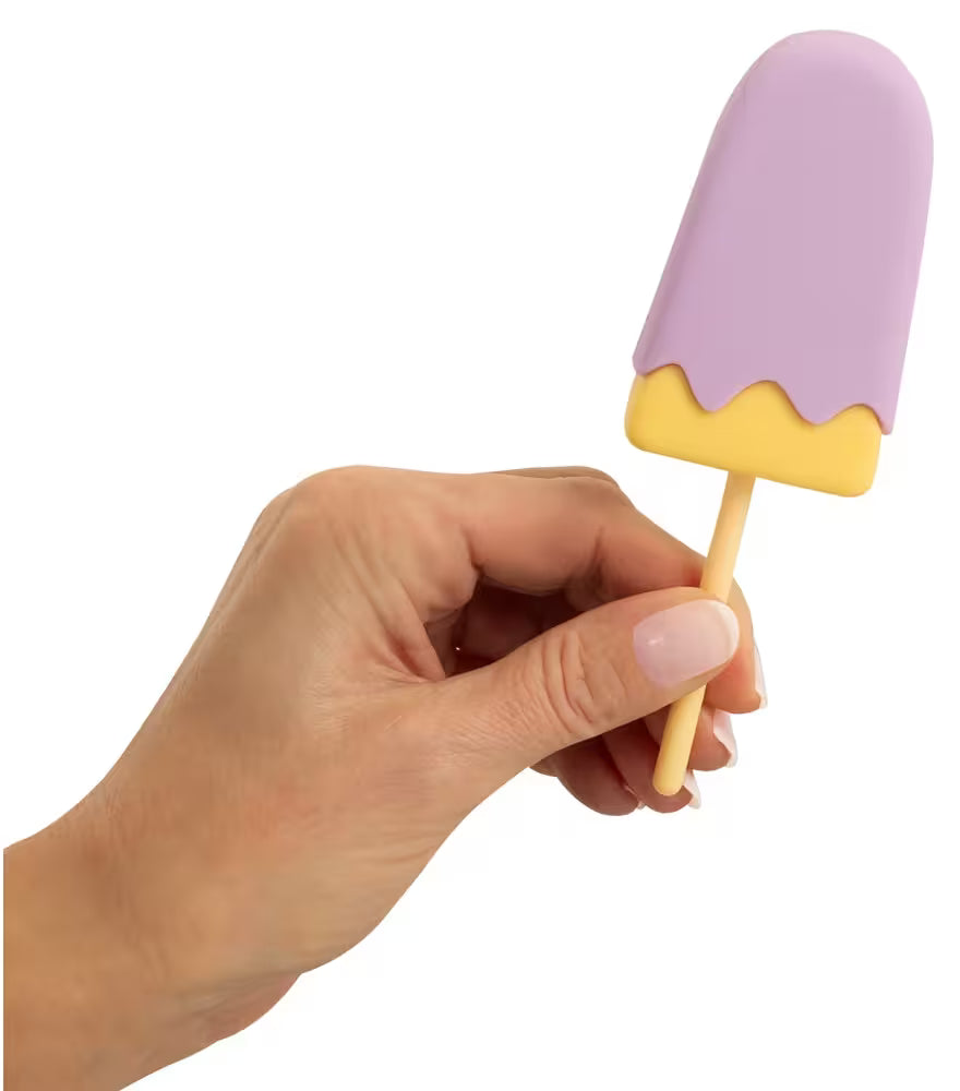 Vibrierendes Eis am Stiel, lila mit gelbem Rand, in der Hand gehalten
