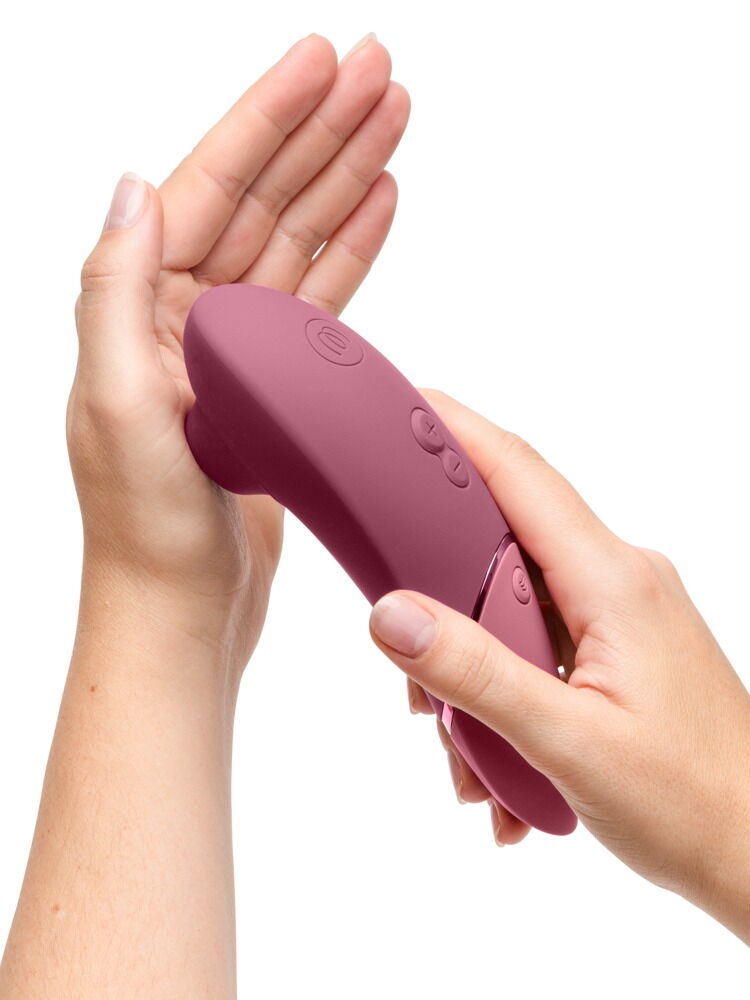 In Händen gehaltenes bordeauxfarbenes Handgerät des Clitorisstimulators