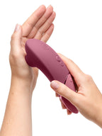 In Händen gehaltenes bordeauxfarbenes Handgerät des Clitorisstimulators