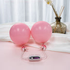 Paar pinke Nippelklemmen mit Bedieneinheit und angeschlossenem Kabel