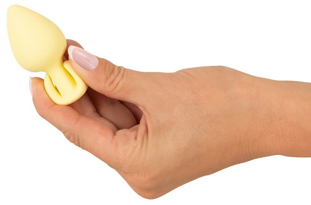 Mini-Butt-Plug gelb mit Flansch, in Hand gehalten