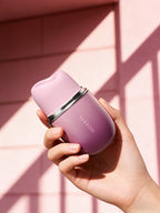Hand hält Auflegevibrator SVAKOM Klitty in violettem Gehäuse mit silbernem Ring